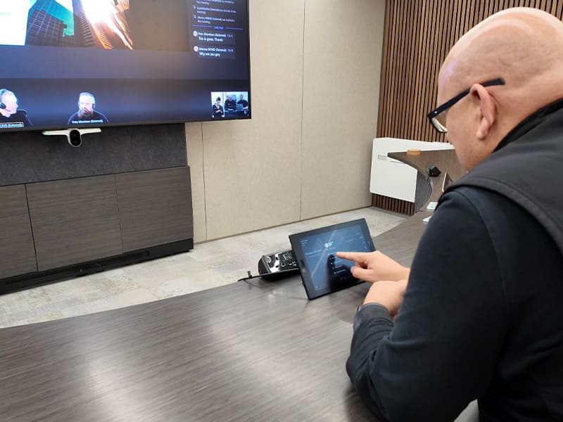 man sitting at a table in front of a flat screen tv